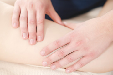 Fototapeta premium Closeup of the arm of a masseur male doing hip massage to a girl in a spa salon. Massage and body care concept