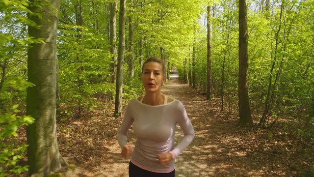 Woman Jogging Through Forest