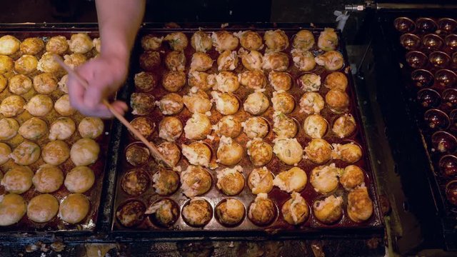 Cooking Takoyaki on hot pan Famous food Osaka Japan street food 4K Footage