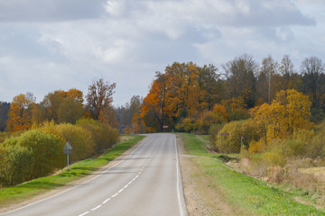 Autumn scene with winding asphalt road in the countryside. 