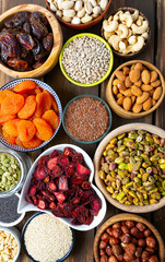 nuts, seeds and dried fruis on wooden surface