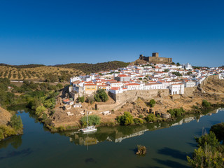 Fototapeta na wymiar Aerial view of the town of Mértola in southeastern Portuguese Alentejo destination region, located in the margin of Guadiana River, whit its medieval castle, located on the highest point. Portugal.