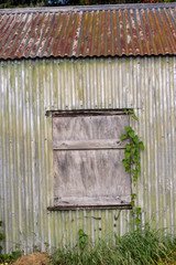 Boarded up window of old rusty shed