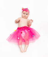 Portrait of a sweet infant wearing a pink tutu and headband bow, isolated on white