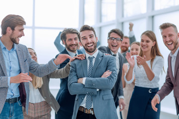 Obraz premium pewnie dumny biznesmen stoi przed przyjaznym zespołem biznesowym.