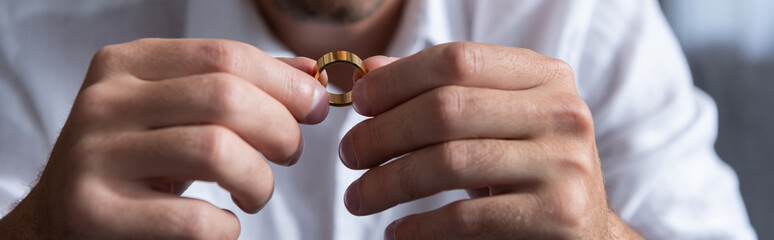 panoramic shot of man holding ring at home