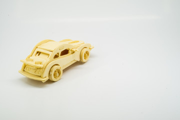 Wooden figurine of a car on a white background. Minimalism. The concept of car insurance, buying and selling cars. Repair and maintenance of vehicles. A wooden toy. banner