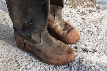 Old worn muddy boots. Old ragged shoes.
