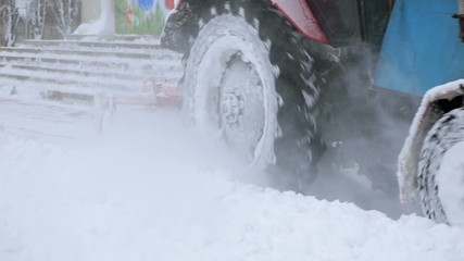 Backhoe loader scraper snow by claw bucket plow, tractor move backward, then close blades, turn and pour out snow to road side. Removing snow with plow.
