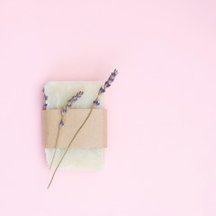 Natural lavender soap in a package on a pink background, top view