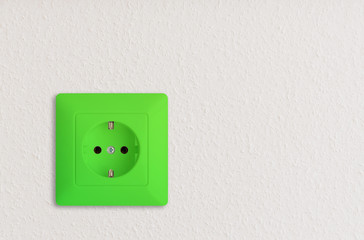 green electric power outlet on white wall, green electrical power socket on white wall, green power