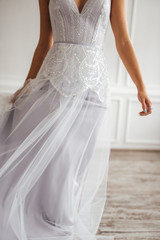 Fototapeta na wymiar the bride in a beautiful dress is spinning in a white Studio