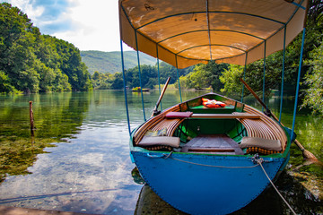Small boat with oars floating on the pristine clean waters of a natural lake.