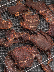 background of dried meat slices in dehydrator on metal tray, meat snack