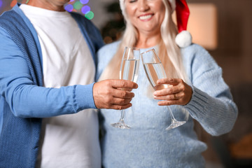 Mature couple with glasses of champagne celebrating Christmas at home