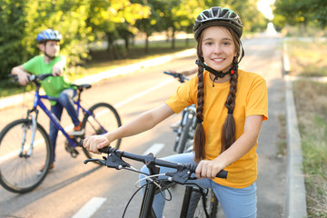 Naklejka premium Cute children riding bicycles outdoors