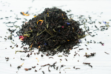 Mix of black and green tea with flower petals on a white background.Close-up.