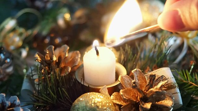 Gurka lights a candle with a match. Christmas decorations candle is lit.