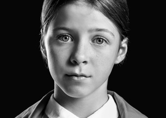 Black and white portrait of sad little girl on dark background