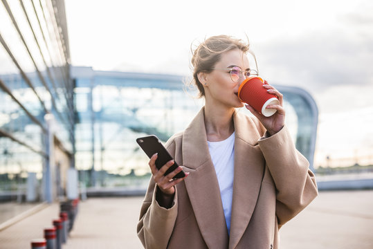 Business Woman Using Phone Near Airport Entrance