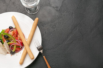 Fototapeta premium Plate with tasty Greek salad on dark background