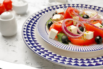 Plate with tasty Greek salad on table, closeup