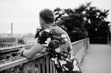 Fototapeta premium Lifestyle portrait of handsome man posing on the street of city and looking at train station.
