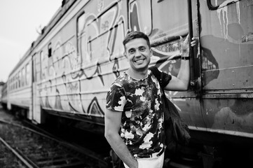 Fototapeta na wymiar Lifestyle portrait of handsome man with backpack posing on train station.