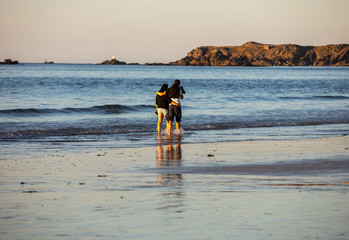 Romantic walk of a couple in love on the beach in Saint Malo. Brittany, France