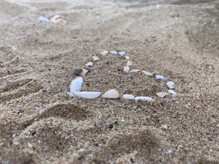 Ein Herz aus Muscheln im Sand