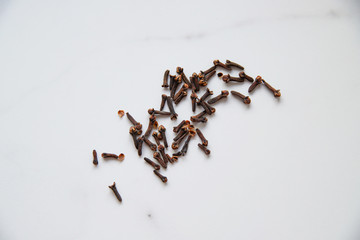 Dried cloves on grey marble background. Spice for hot tea, winter drinks and food. Close up and top view