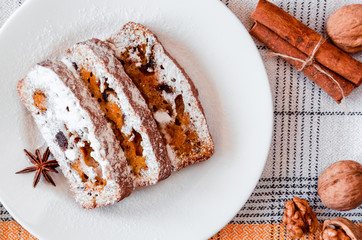 Homemade carrot cake with walnuts and dried fruits, sprinkled with powdered sugar. Healthy desserts. Healthy eating concept