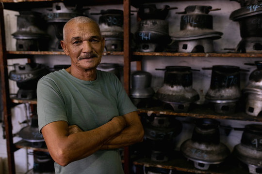 Man standing with crossed arms in a hat factory