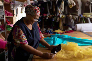 Middle aged woman using tablet at a hat factory