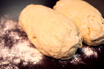 A dough with flour on the black background. Homemade food concept