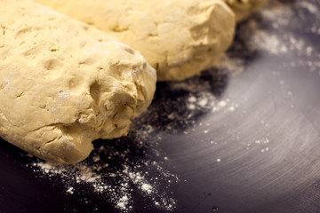 A dough with flour on the black background. Homemade food concept