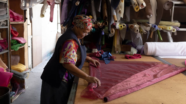 Middle aged woman working at a hat factory