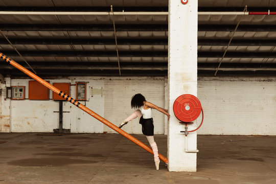 Female dancer in an empty warehouse - Powered by Adobe