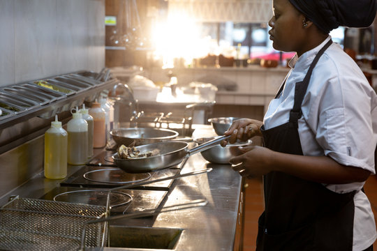 Woman frying in restaurant kitchen