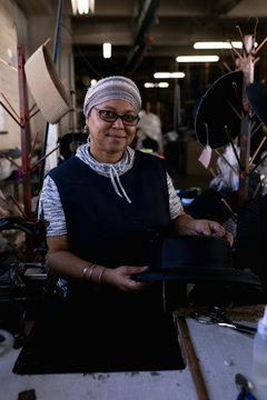 Portrait of a woman working in a hat factory