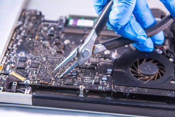 fixing a hard disk drive with one hand with gloves and a special tweezers