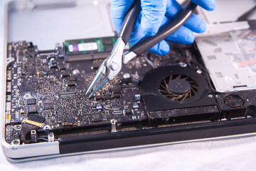 Naklejka premium fixing a hard disk drive with one hand with gloves and a special tweezers