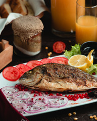 Baked fish with onion pomegranate and tomato