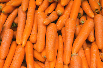 Fresh orange carrot close up at the market. Organic product suitable for vegetarians and vegans.