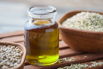 Organic hemp oil and hemp seeds on rustic background