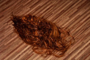Cut long red hair on the floor in a hairdressing salon, red cutted hair in a beauty salon