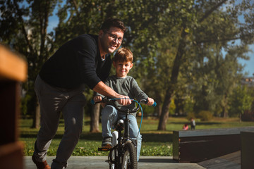 Obraz premium Father Learning his son to ride a bicycle 