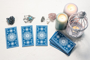 Blue tarot cards on white stone table background.