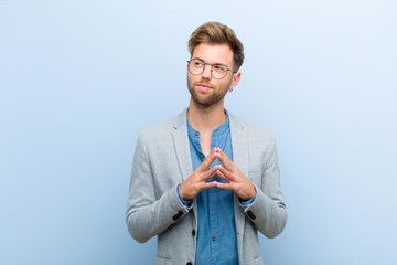 young businessman scheming and conspiring, thinking devious tricks and cheats, cunning and...