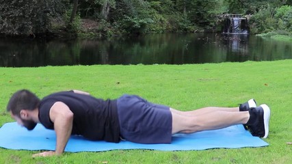 Man doing clap push ups in park